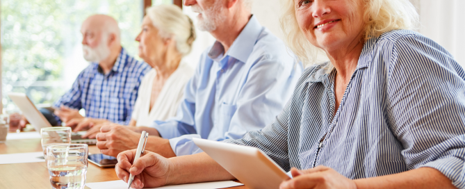 Group of older adults sitting at a desk studying