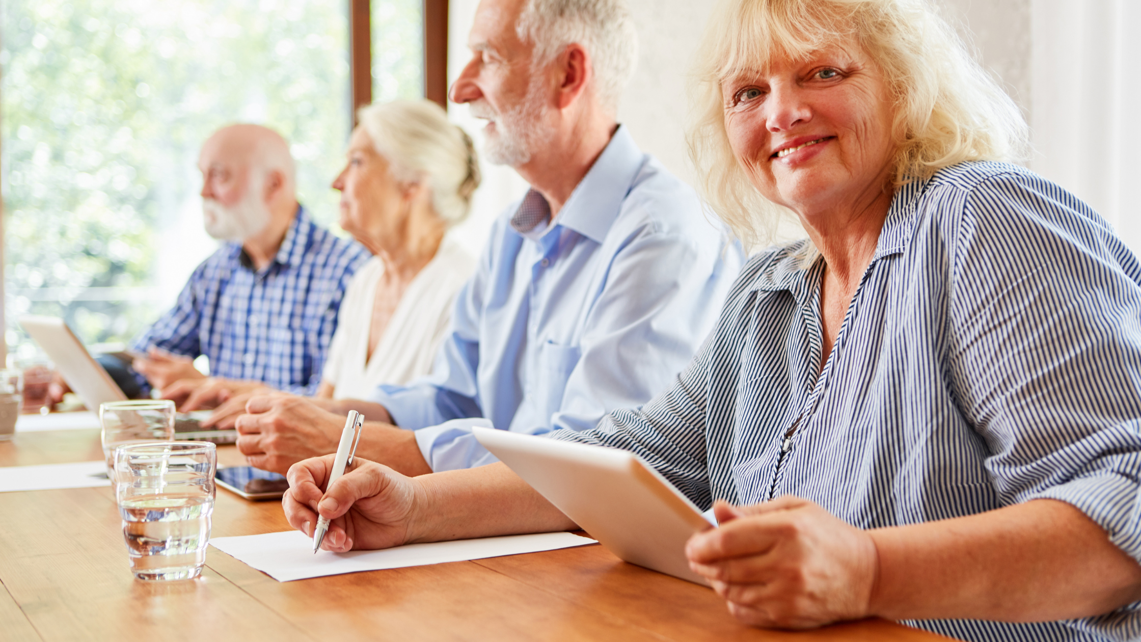 Group of older adults sitting at a desk studying